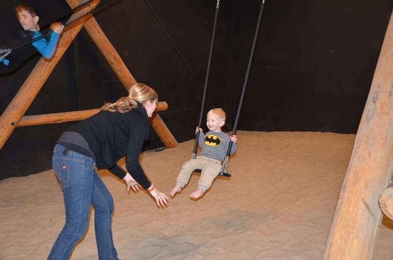 Billedet viser en lille dreng der svinger på en gynge.