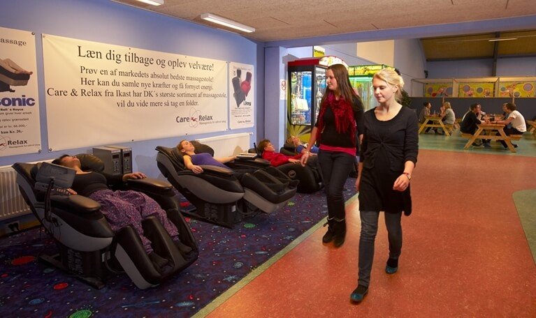 et billede af to kvinder der går forbi et par optagede massagestole